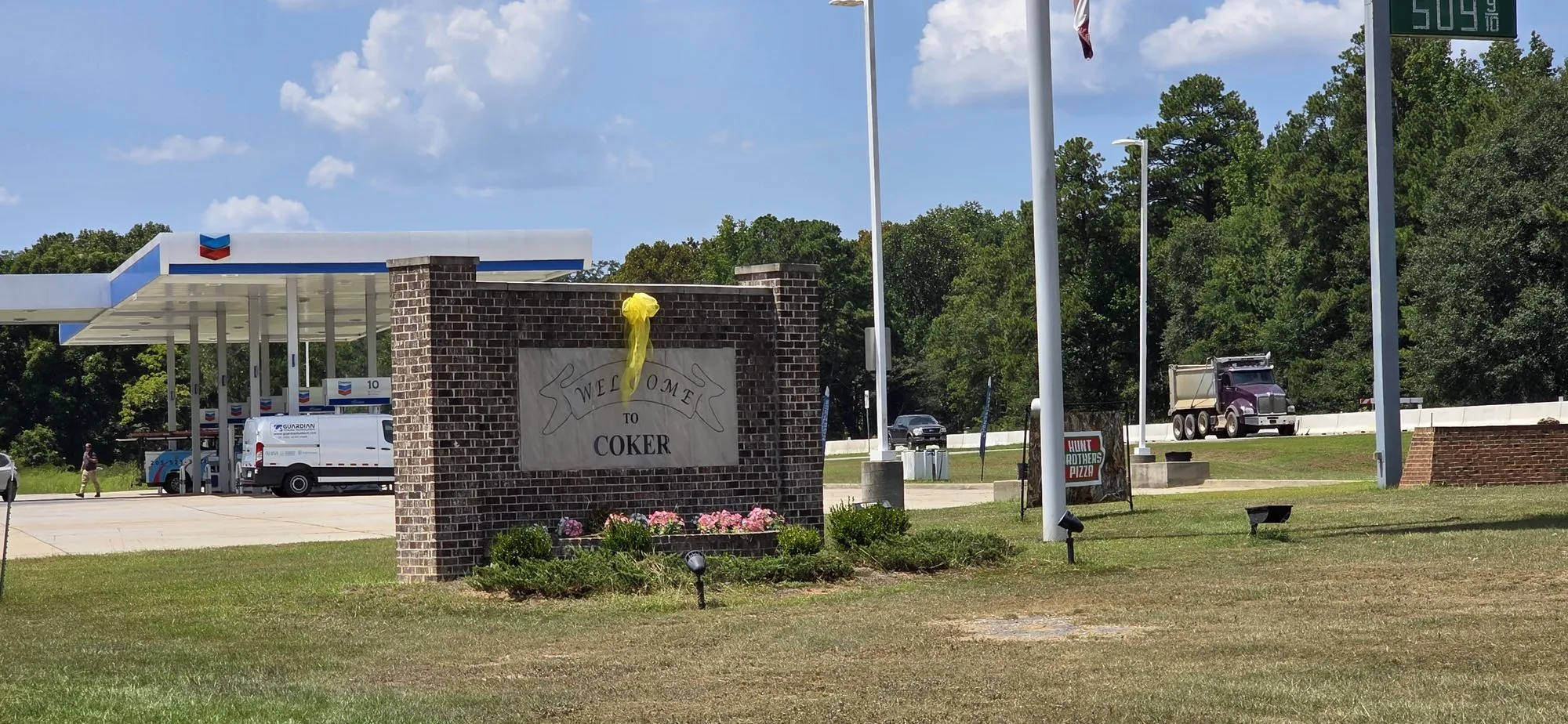 Welcome monument and flags at the entrance to Coker