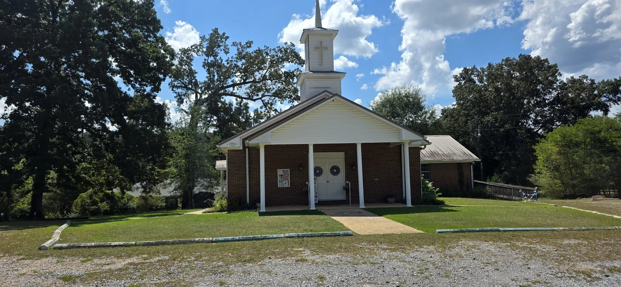 Brick and white-frame church with a steeple in Vance