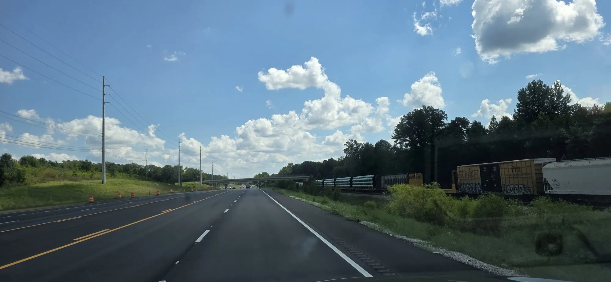 Four-lane highway past a rail siding at Vance